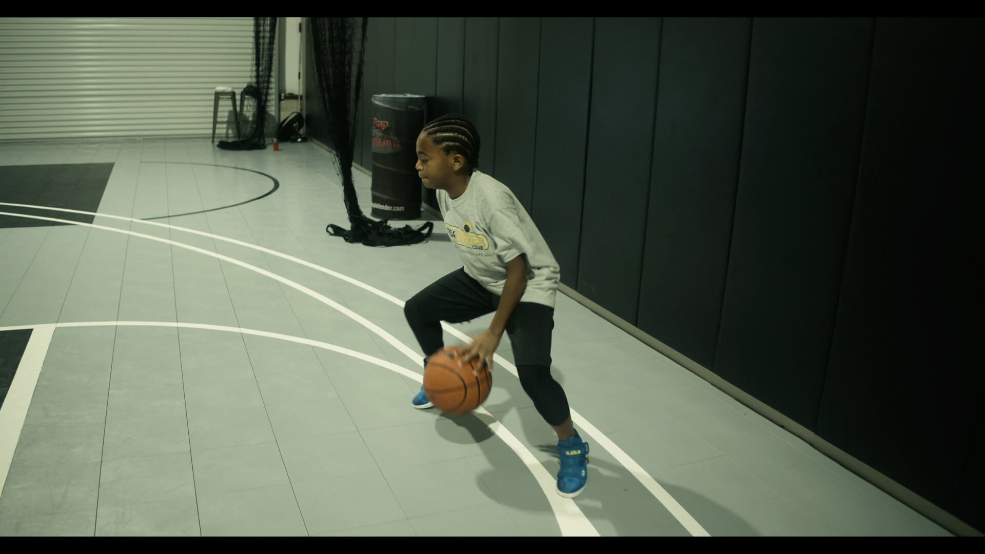 Young basketball player dribbling on court.
