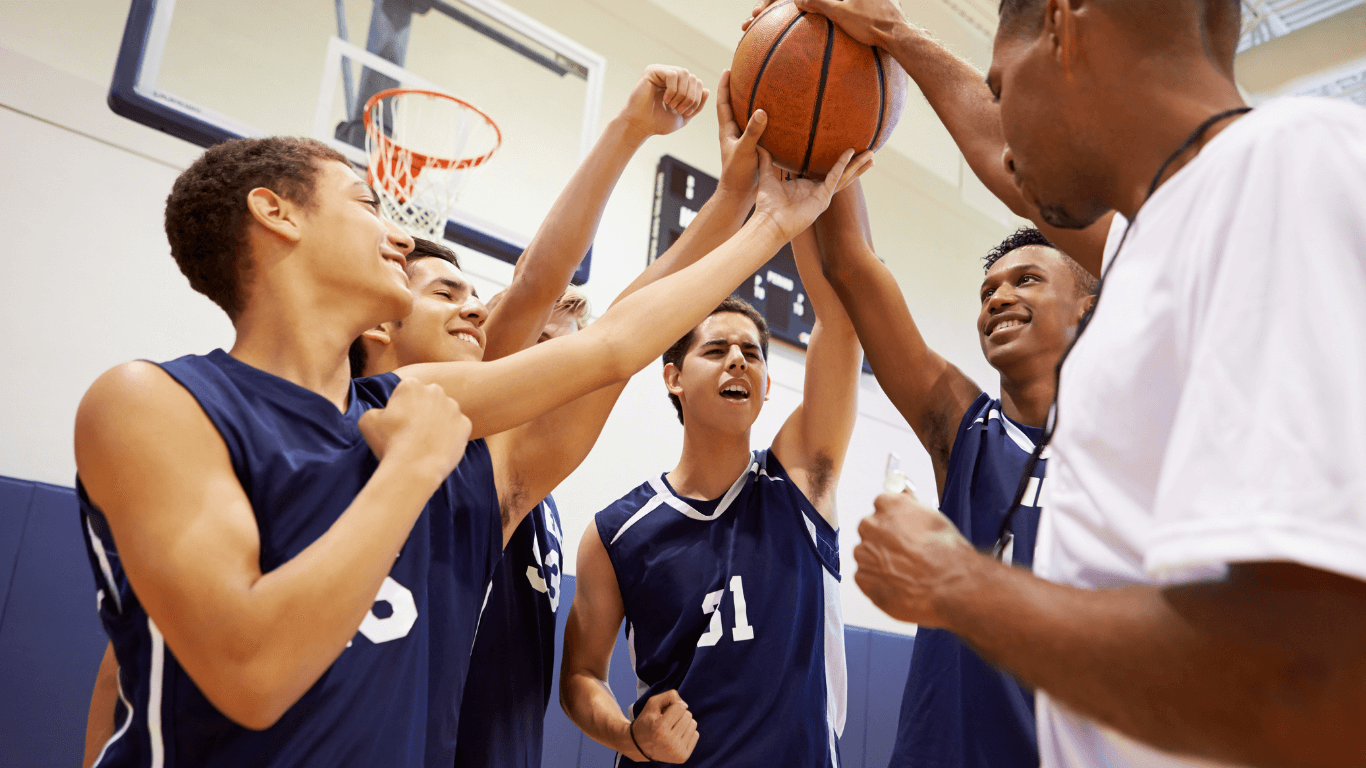 Basketball team celebrating with their coach.